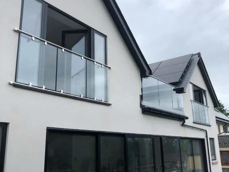 Glass Juliet balconies on an apex-roof Swansea home by Swansea Glass Balustrades