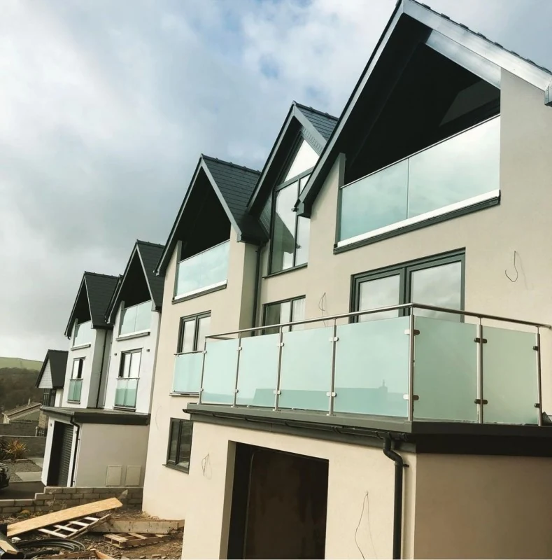 glass-balcony-juliet-balconies-grey-apex-houses-swansea-swansea-glass-balustrades Glass balcony balustrade showing juliet balconies grey apex houses in Swansea by Swansea Glass Balustrades