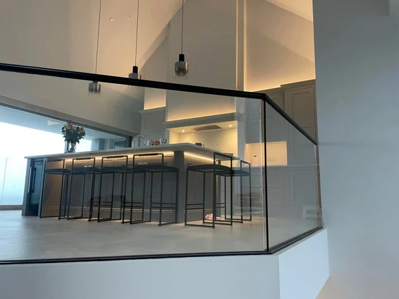 glass-balustrade-staircase-frameless-landing-kitchen-view-swansea-swansea-glass-balustrades-wide Frameless glass landing balustrade overlooking an open-plan kitchen in Swansea by Swansea Glass Balustrades