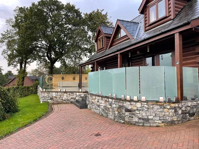 Frosted glass balustrade on a stone-wall patio in Swansea by Swansea Glass Balustrades